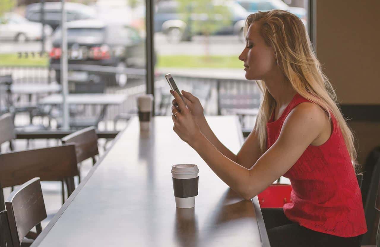 Une femme tenant son téléphone Une femme tenant son téléphone